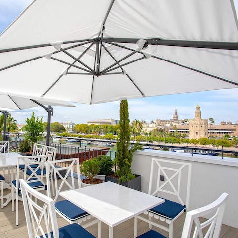 Enjoy a sundowner on the shared terrace with a view of ancient Seville