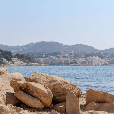 Sit back and relax under the pine trees of Cala Baladrar, a short walk from home