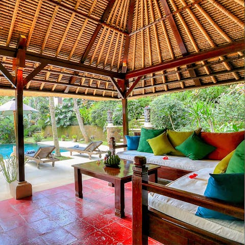 Curl up among the colourful cushions on the shaded balé that overlooks the pool and Paliminan stone terrace