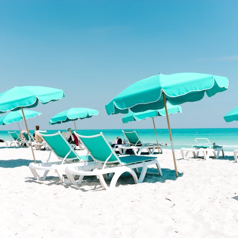 Hire yourself a pair of loungers and parasol, ideally in turquoise to match the water