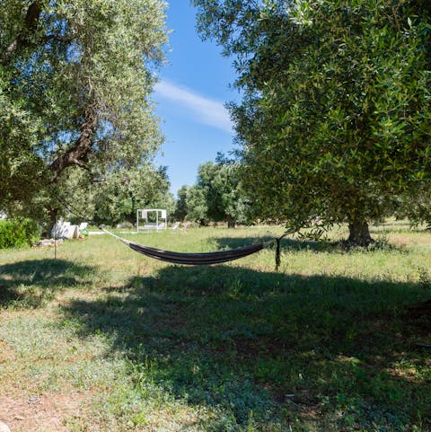 Reach ultimate relaxation lying in the garden hammock tied between olive trees