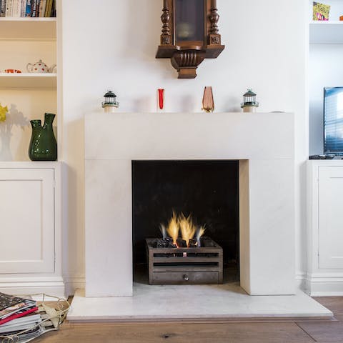Cuddle up by the contemporary fireplace with a mug of tea and a good book