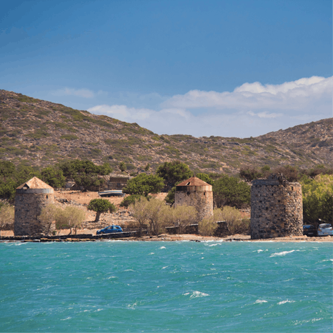 Visit the quaint old windmills along the beach in Elounda