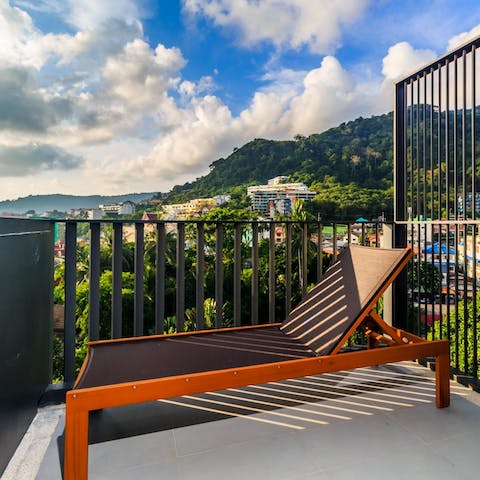 Relax on your private balcony, overlooking the luscious mountains with a glimpse of the twinkling sea