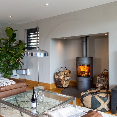 Warm up by the modern wood-burning stove in the cosy living space