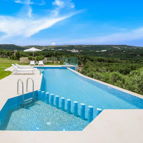 Splash about in the infinity pool with the Aegean Sea in the background