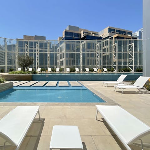 Enjoy a refreshing morning dip in the shared outdoor pool, complete with loungers