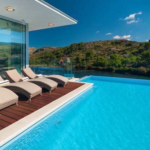 Relax on a sun lounger or in your infinity pool with stunning bay views