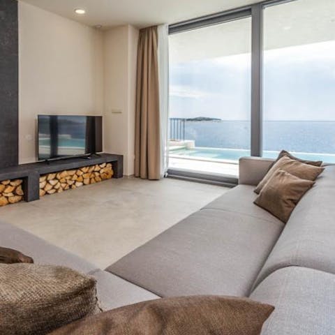 Snuggle up for a movie night in the luxurious living room, with a fireplace and stunning vistas 