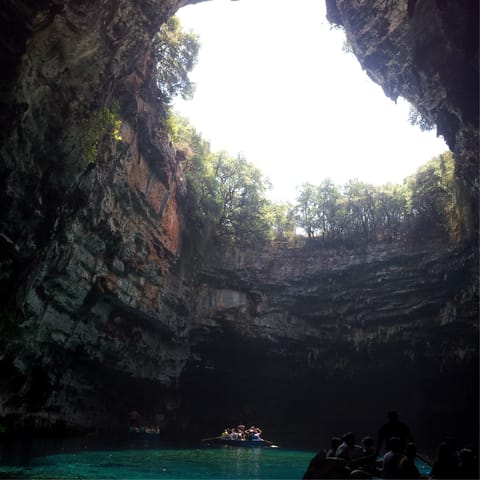 Float on the incredibly clear waters of Melissani Cave, eight minutes away
