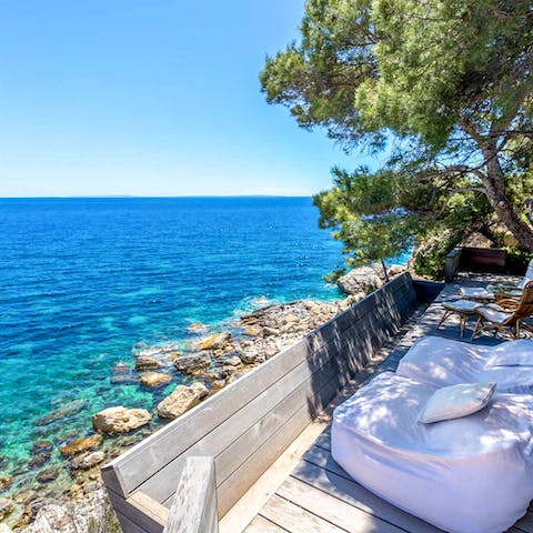 Lounge the day away on a day bed, with your private beach below