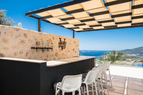 Mix up some cocktails and serve up to guests at the bar under the pergola