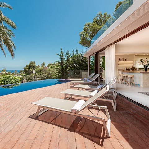 Lay out on the loungers by the pool, looking out over the ocean