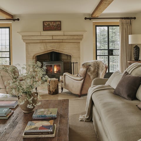 Take a seat in front of the log burner on the armchair with its faux fur throw