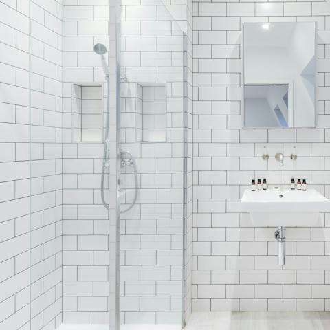 Start mornings with a relaxing soak under the metro-tiled bathrooms' rainfall showers