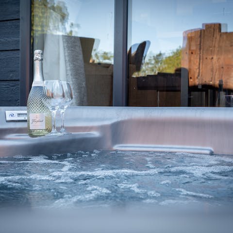 Relax in the hot tub with a glass of something bubbly in hand