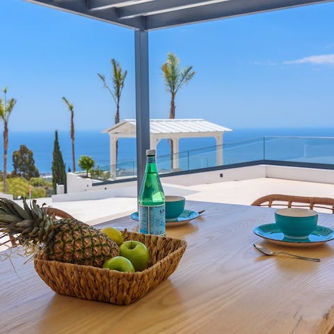 Enjoy a morning coffee at the outdoor dining table with stunning sea views before you