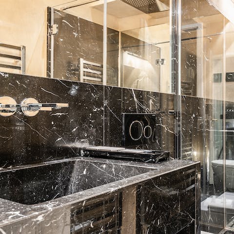 Pamper and preen in the opulent black marble bathroom