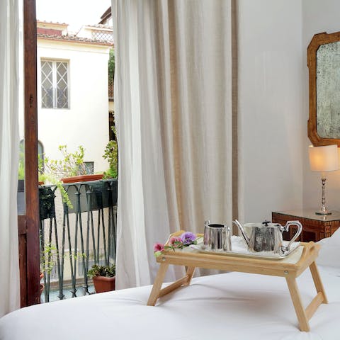 Open the French doors to the balcony and enjoy breakfast in bed