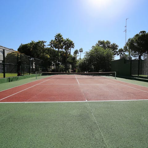 Keep up a routine by playing a few sets of tennis on the communal court