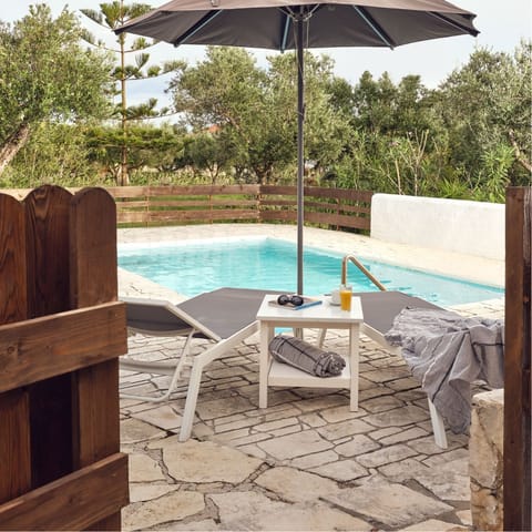 Relax under the parasol after a dip in your private pool 