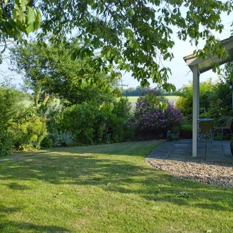 Enjoy lazy afternoons with a cup of tea in the lush garden with countryside views