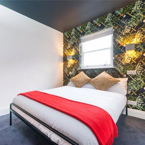 Sleep soundly in the cosy bedroom with a tropical feature wall