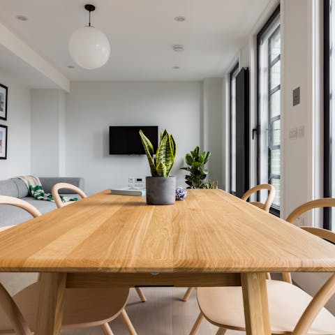 Gather your crew around the dining table, lit by floor-to-ceiling windows