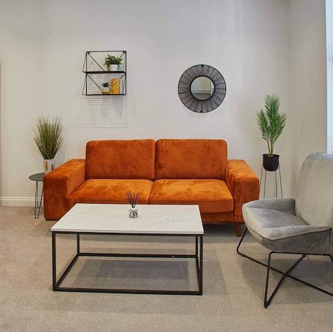 Mix a G&T and get comfy on the bright orange sofa 