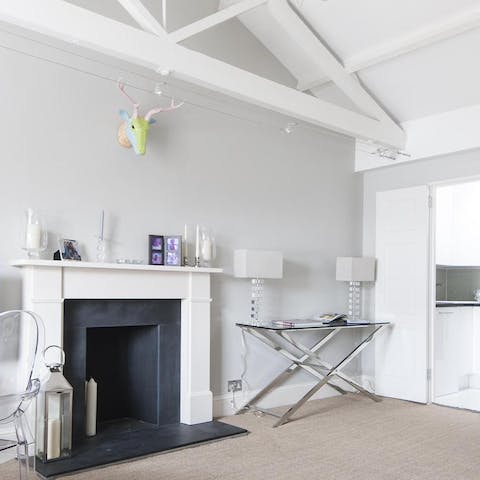 Relax in a characterful living room with rustic painted beams and an ornamental fireplace