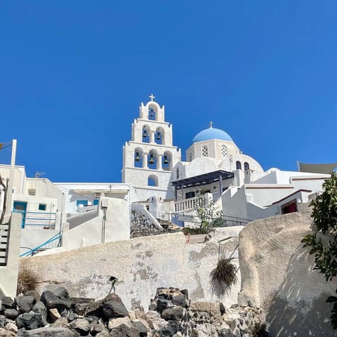 Stay in Santorini, with its iconic blue domes and whitewashed houses