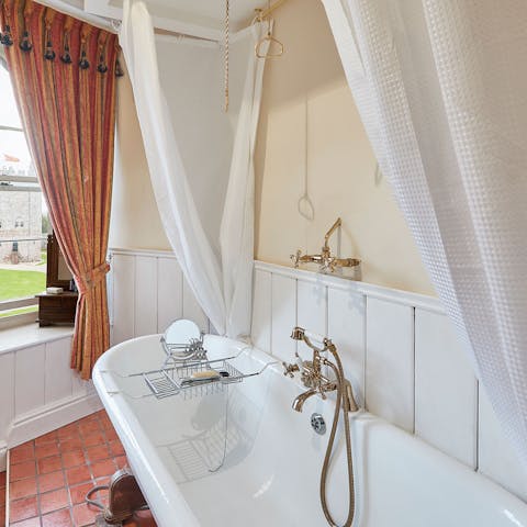 Sink down into the bubbly water of a hot bath with a view of the castle through the window