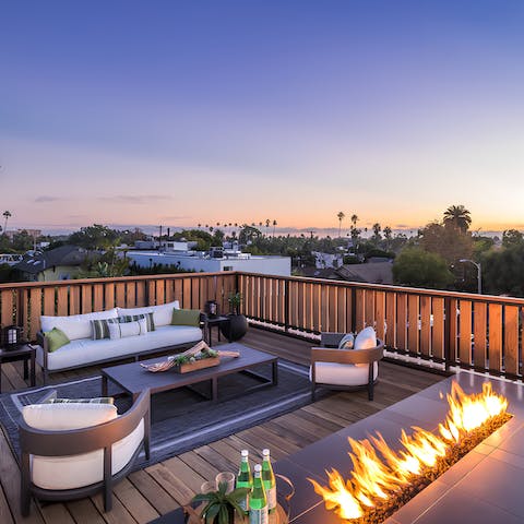 Warm up around the fire while watching the sunset from the roof 